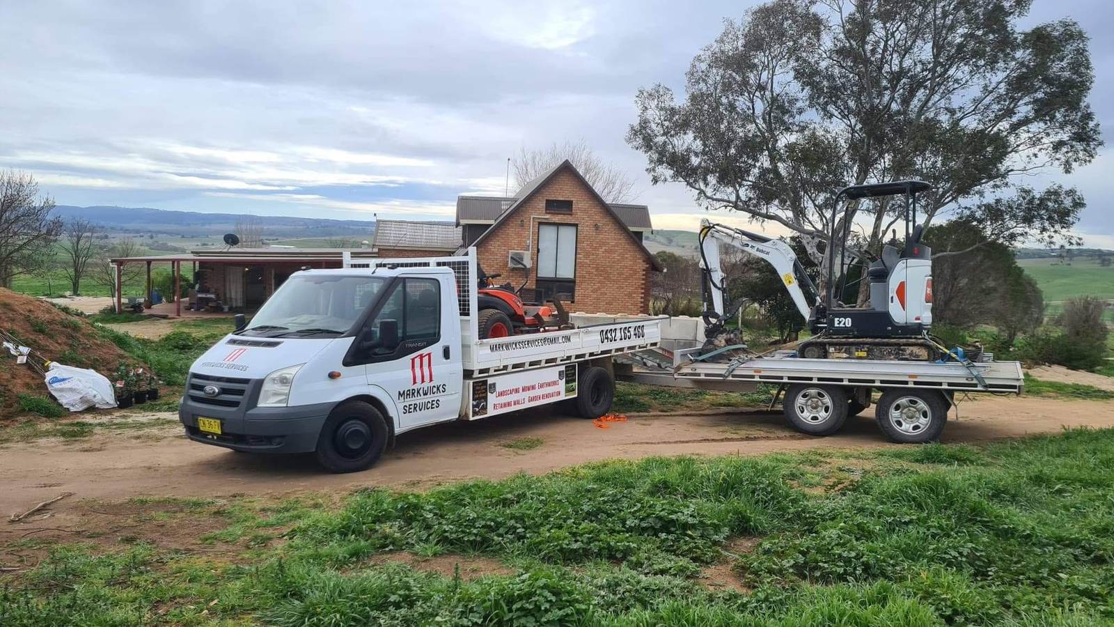 Markwicks Services truck and trailer with excavator and mower on site